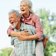 Smiling couple embracing outdoors (actor portrayal)