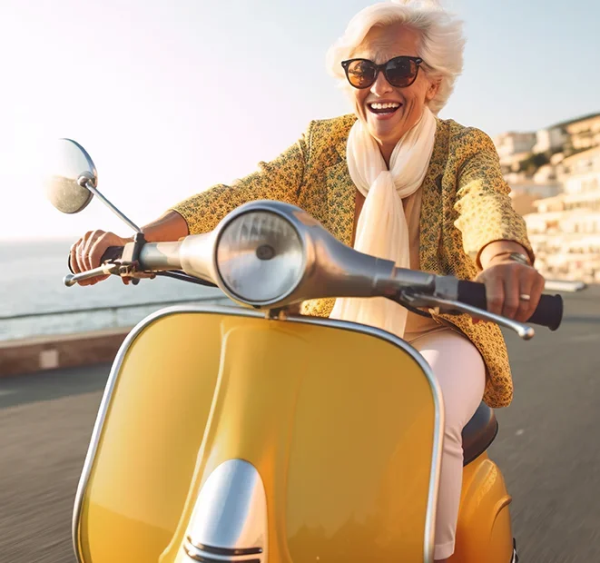 Smiling woman riding a scooter along a coastal road