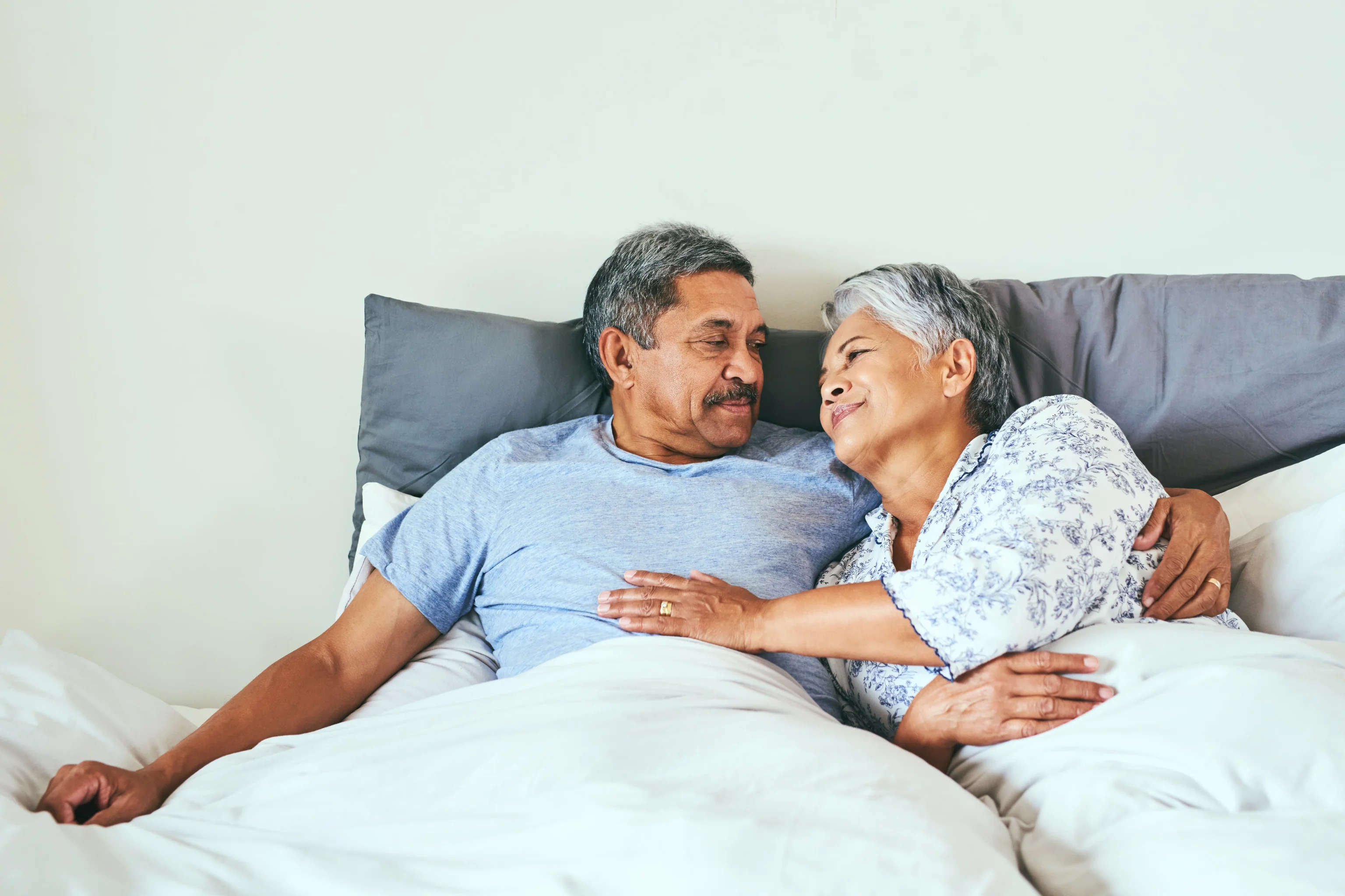 Smiling couple embracing in bed